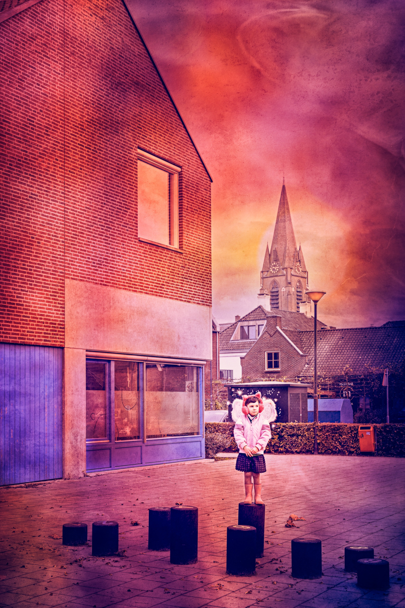 A young girl stands on a wooden stump in a quiet urban square, dressed in a pink coat and fairy wings, gazing dreamily ahead. Behind her, a church steeple rises against a vibrant, dreamlike sky, blending magic and everyday reality in a scene inspired by Neverland...Just think of happy things and your heart will fly on wings, forever...in Never Neverland