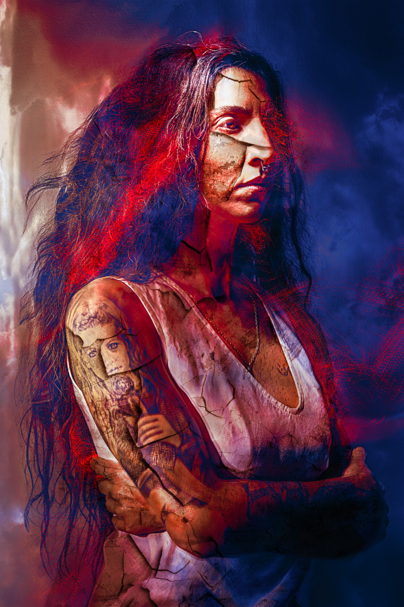A dramatic, artistic portrait of a woman with long hair, visible tattoos, and a cracked, textured overlay effect, surrounded by dark blue and red colors.
