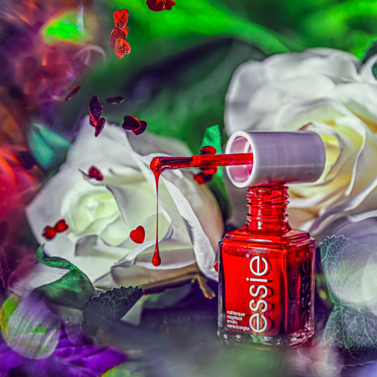 dripping red nail polish with white roses in the background