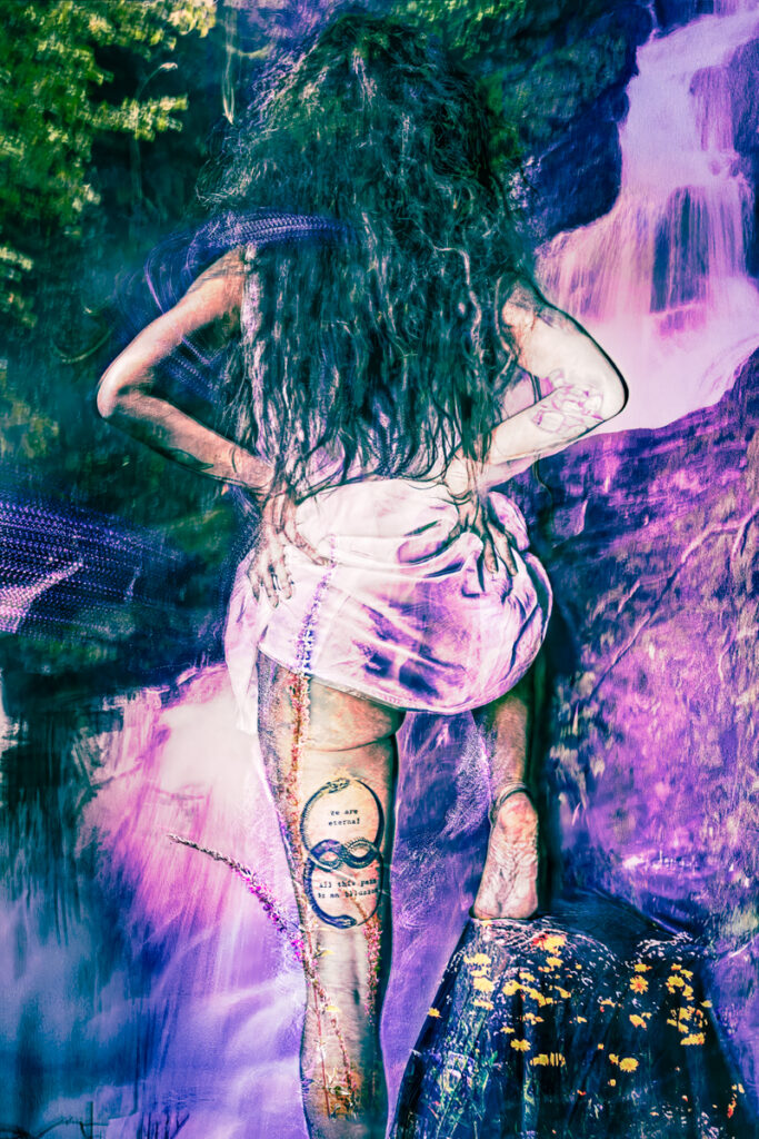 A surreal, vibrant image of a person standing on a rock in front of a waterfall, with long wavy hair, hands on hips, and a tattoo on their thigh featuring an infinity symbol and the words "we are eternal, all this pain is an illusion." The scene is awash in electric purples and blues, blending natural and dreamlike elements.